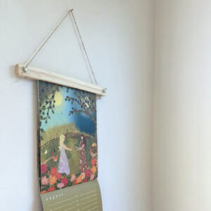 Use a wooden poster hanger or foldable clip to hang the Studio By Nicolet Calendar.